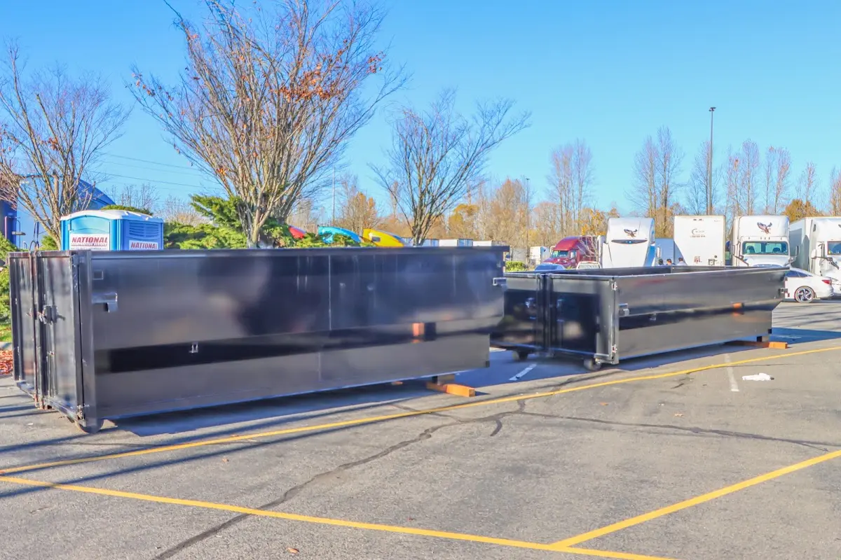 Professional dumpster rental service with roll-off container on residential driveway in Clark